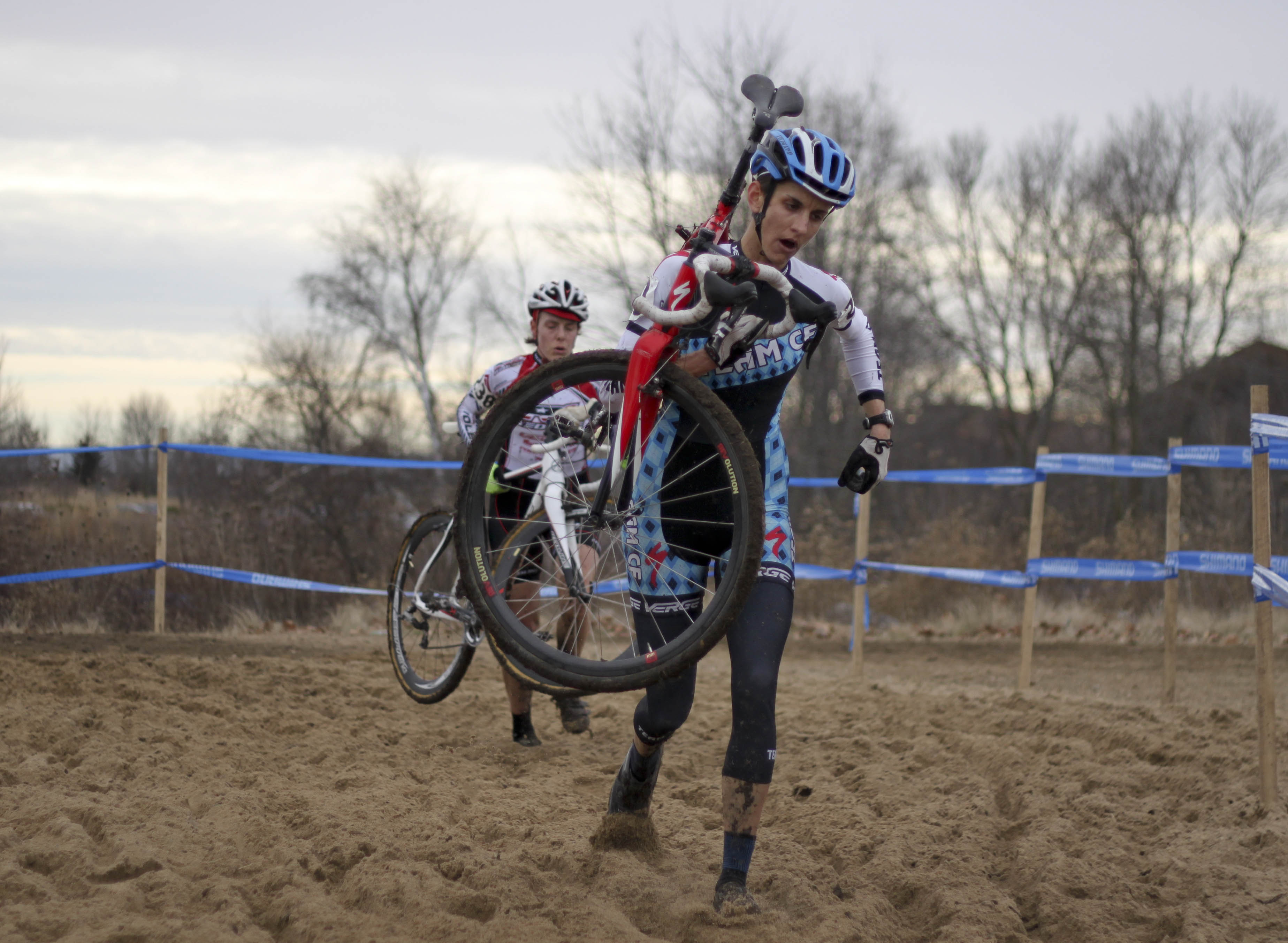 Nicole Thiemann leads a rider through the sandpit. © Cyclocross Magazine
