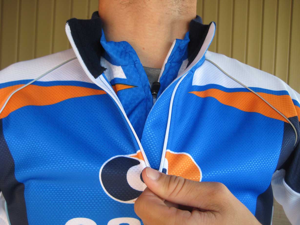 Layered with the short sleeve jersey, the wind jacket's zipper has a full length backing to keep the breeze from chilling your core.  The tall stand up fleece collar is nicely finished and keeps your neck toasty throughout your ride. by Kristie Hancock