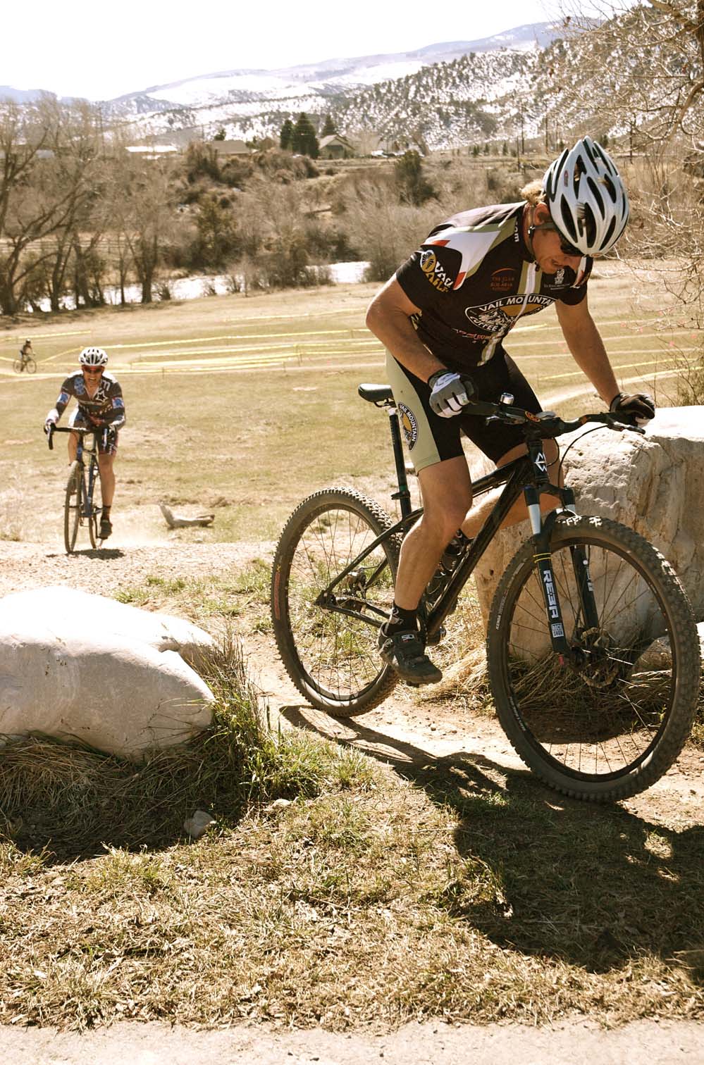 Bo Pihl hammers up a climb on his singlespeed as Courtney Gregory is fast approaching. by Karen Jarchow