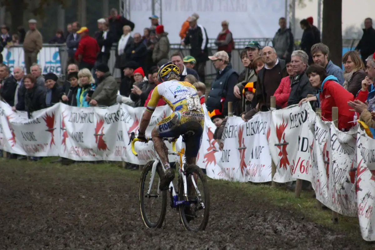 The crowd urges Wellens through the mud © Bart Hazen