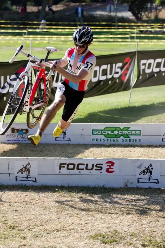 Zach McDonald clears the barriers surrounded by his Focus sponsor logos © Mark Colton