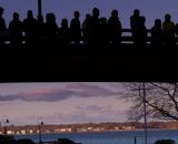 Silhouetted spectators watch the race from the bridge overlooking the finish line. © Todd Prekaski