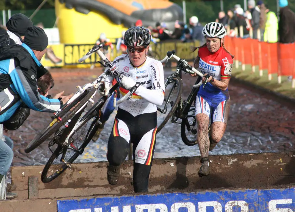 Kupfernagel (l) and Van Den Brand going over the barriers in the mud. ? Bart Hazen