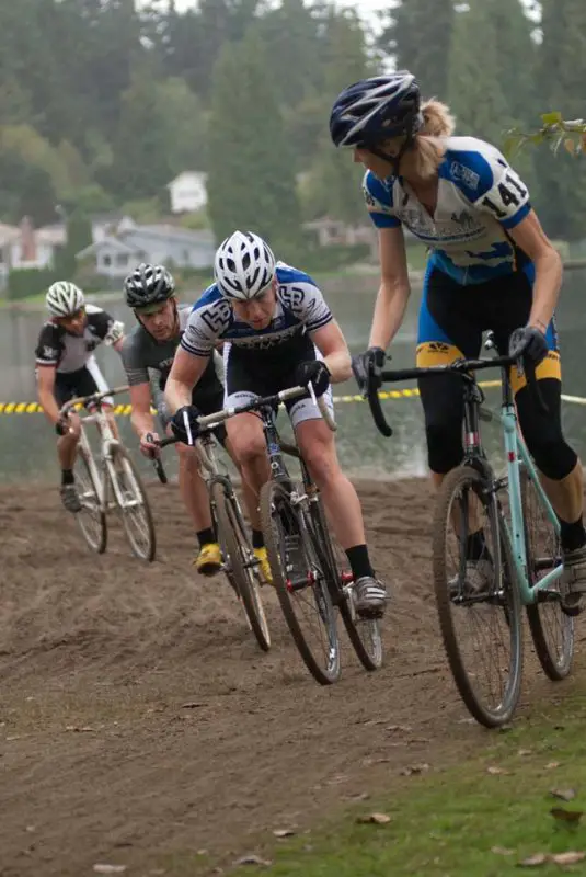 Jodi Connolly of the Blue Rooster cycling team looks over as the men's field approaches to her right © Karen Johanson