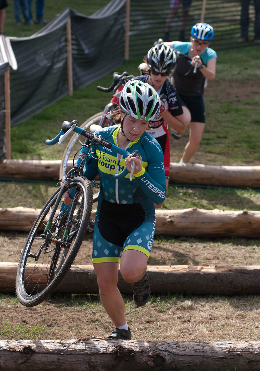 The women\'s cat 3/4 field leaps over log barriers. © Karen Johanson