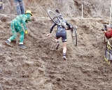 An Elite racer receives attention from the Green-Shamrock Man at the top of the run-up © Tim Westmore