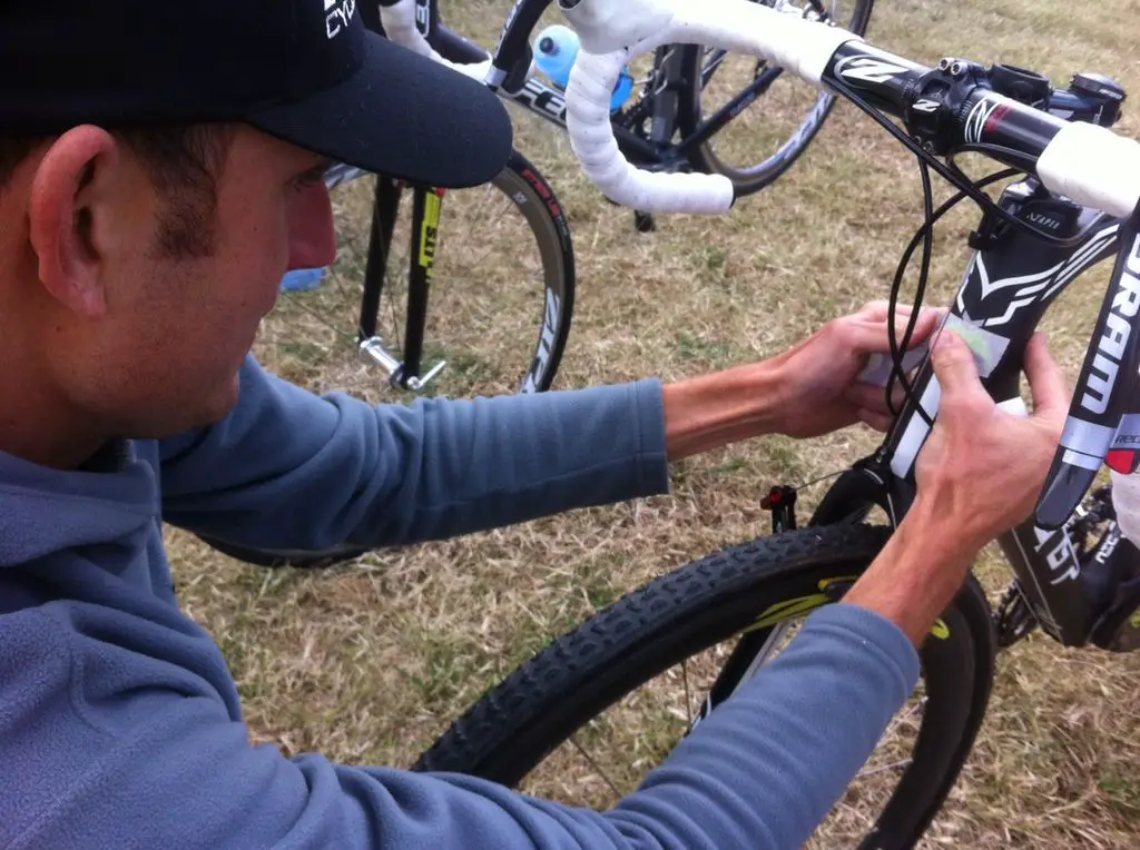 Trebon putting a Pioneer S-Mustache sticker on his head tube.  