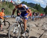 Adam Craig pushes it in the rocks as 10 year old racer Andy Schmidt watches in awe. ©Amy Dykema