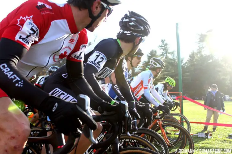 At the men’s start grid, some riders kept their eyes forward, while others battled the glaring sunlight to see the official preparing to blow her whistle. © Andrew Reimann