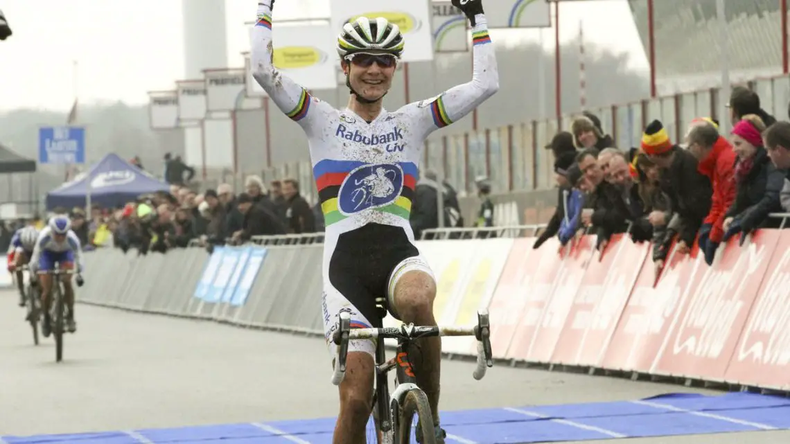 A victorious Vos puts her arms up as Nash sprints behind. © Bart Hazen/Cyclocross Magazine