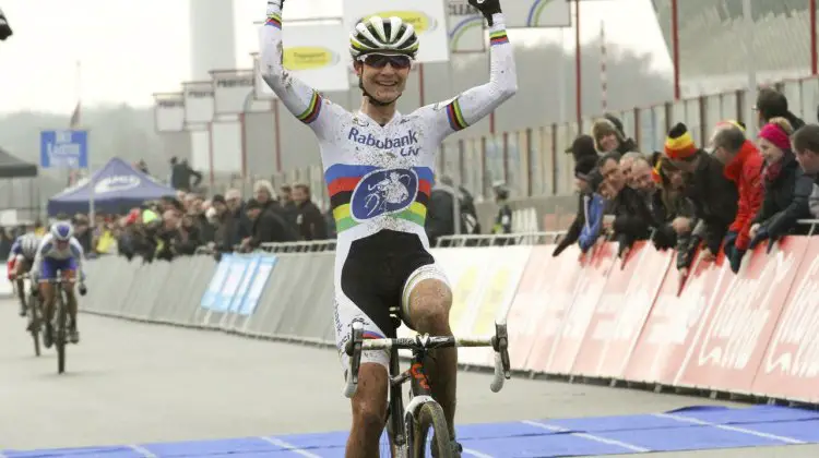 A victorious Vos puts her arms up as Nash sprints behind. © Bart Hazen/Cyclocross Magazine