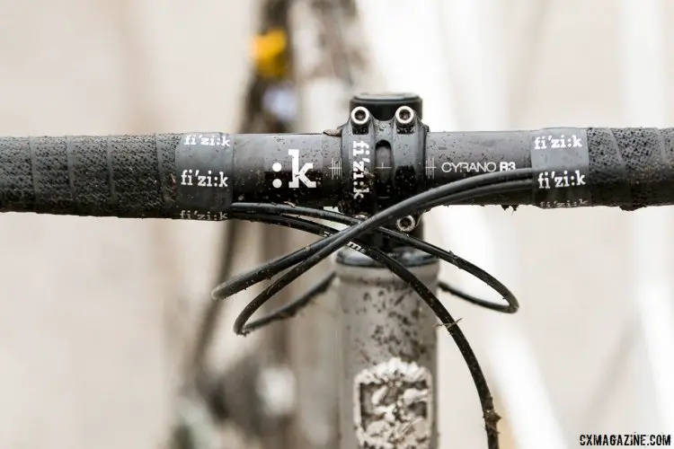 Hecht’s stem and handlebars are Fizik Cyrano R3, aluminum components designed for the Bull subset of the company’s Spine Concept model they use for their saddles. The tape is matching Performance Soft Touch. © Cyclocross Magazine