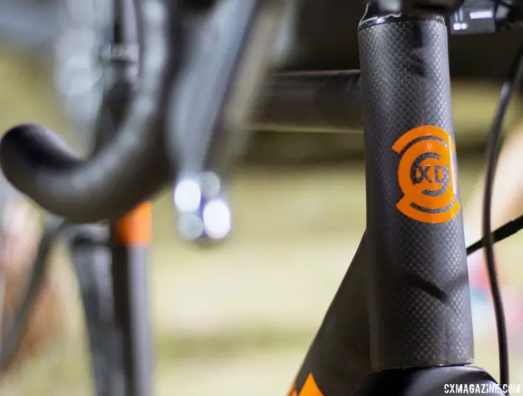 The headbadge of the Parlee Z-Zero XD is painted in "Lambo Orange," and sits over the waxed surface of the bare carbon frame. © Cyclocross Magazine