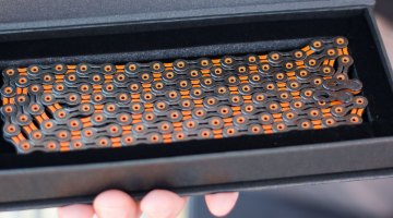 KMC $140 DLC 11 (Diamond-Like Coating) is KMC's top-of-the-line chain, and comes in a new black and orange color scheme that matches CXM's logo. Regardless of colors, the chain is said to offer 5,000 miles, compared to 3,000 miles for a standard chain (road conditions). Sea Otter Classic 2016. © Cyclocross Magazine