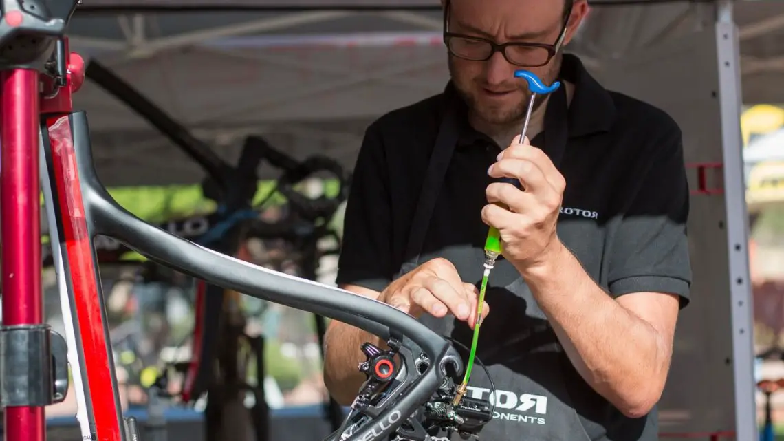 Wolfgang Turainsky tapping out the bubbles, and bleeding the system in just a few minutes. The Uno hydraulic shifting component group from Rotor. © Cyclocross Magazine