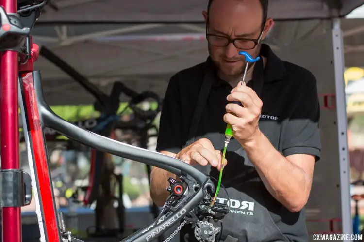 Wolfgang Turainsky tapping out the bubbles, and bleeding the system in just a few minutes. The Uno hydraulic shifting component group from Rotor. © Cyclocross Magazine