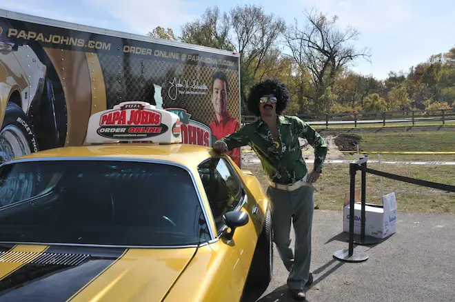 Bob Bobrow in the 70's disco mode poses with Papa John's orginal Camaro at Storm The Greens Cyclocross Race, Louisville, KY October 30, 2011
