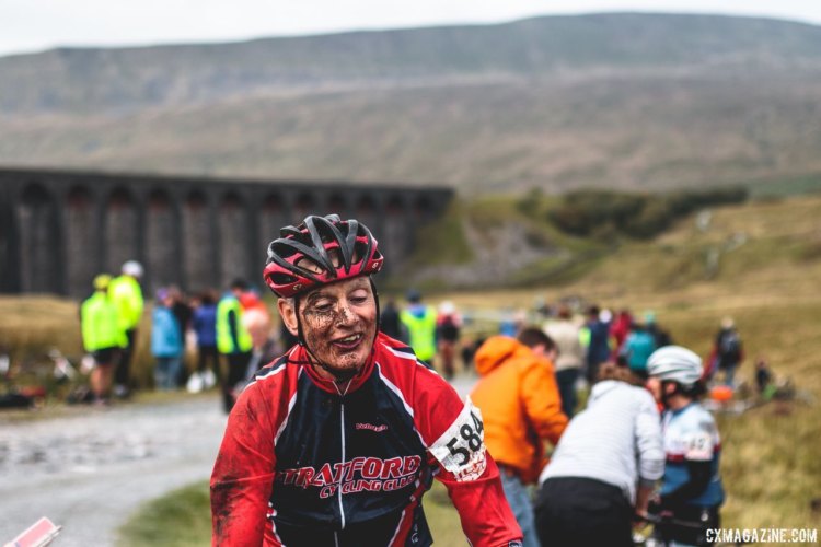 John Johnson shows off his smile and the mud he accumulated when he reached the Ribblehead Viaduct. 2017 Three Peaks Cyclocross. © D. Monaghan / Cyclocross Magazine