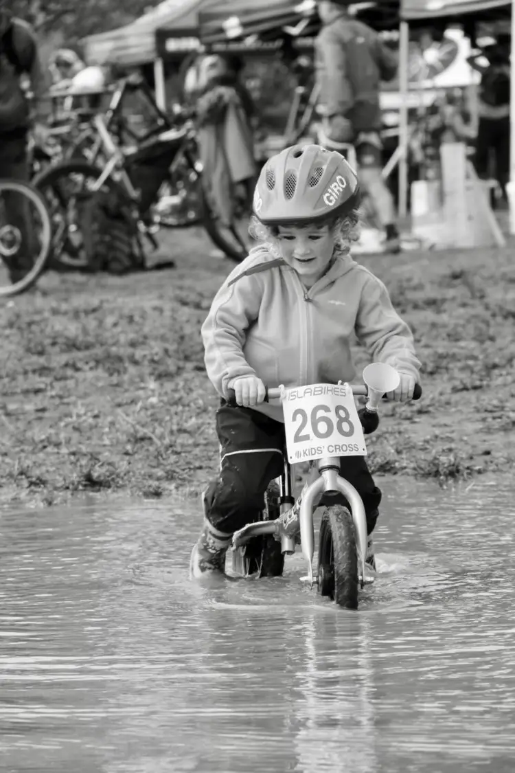 A young CX racer plays in the perfect mud puddle. © M. Estes / Cyclocross Magazine
