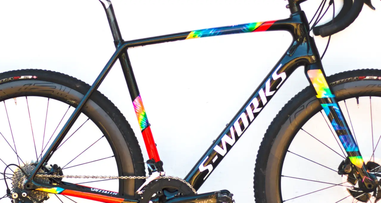 The flattened underside of the top tube and light weight make the CruX a joy to shoulder. The "Black/Cosmos/Rocket Red/White" color scheme is eye-catching. Specialized's Sean Estes calls the color scheme "hippie camo." 2018 Specialized S-Works CruX cyclocross bike, with Shimano Dura-Ace 9100. © Cyclocross Magazine