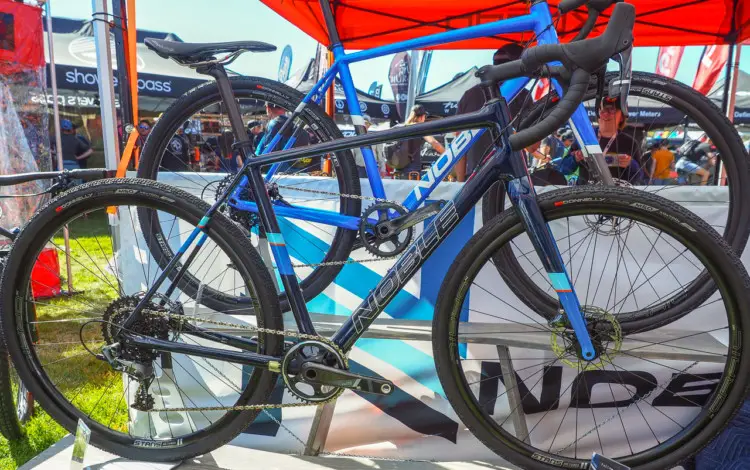 Noble has two gravel bikes. The carbon GX5 is in the foreground and the alloy GX3 is in the background. Both come with 1x SRAM drivetrains and Stan's Grail wheels. Noble Bikes Cyclocross and Gravel Bikes. 2018 Sea Otter Classic. © Cyclocross Magazine