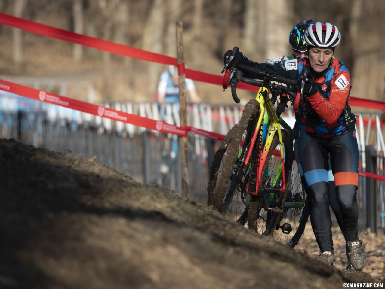 Sheryl Johnson tries to shed some mud from her bike. Masters Women 60-64, 65-69, 70-74, 75+. 2018 Cyclocross National Championships, Louisville, KY. © A. Yee / Cyclocross Magazine
