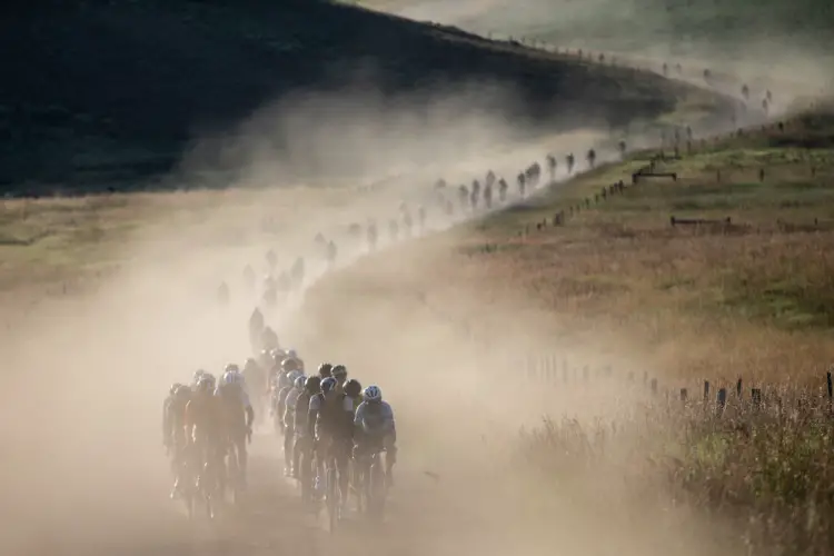 The field rolls down a dusty gravel road. 2019 SBT GRVL gravel race. © Wil Matthews